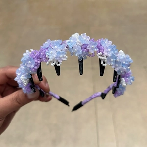 Detail of handcrafted blue and purple beaded flower headband with integrated black hair comb