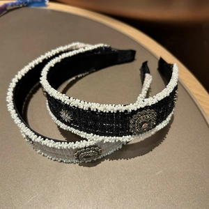 Detail of tweed hairbands with pearl edges and vintage metal buckles on a brown desk
