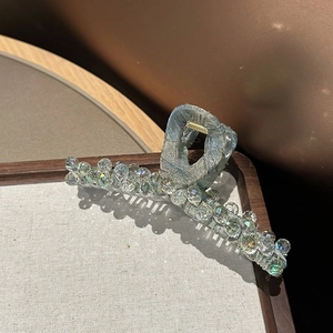 Detailed view of a light blue satin hair claw clip with sparkling aurora crystals and beads