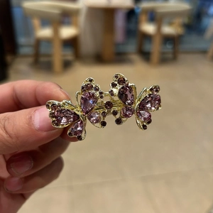 Detail von Doppel-Schmetterling-Haarspange mit rosa Strass und goldener Basis