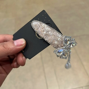 Barrette à cheveux élégante en forme de nœud argenté avec strass, perles et glands