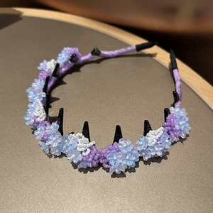 Detail of beaded floral headband with purple ribbon wrap and integrated hair combs