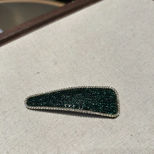 Close-up of sparkling dark green rhinestones on luxury vintage hair clip accessory