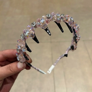 Close-up of pink crystal beads and rhinestones on a non-slip hairband with teeth