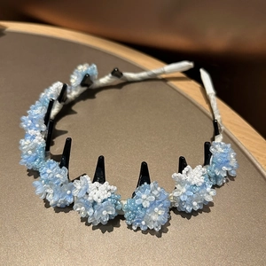 Detailed shot of blue beaded flower headband with integrated hair clips for firm styling