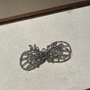 Détail de la pince à cheveux nœud faite main avec perles de cristal gris et fils de métal