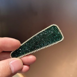 Close-up of luxury rectangular BB hair clip with green rhinestones and silver alloy frame