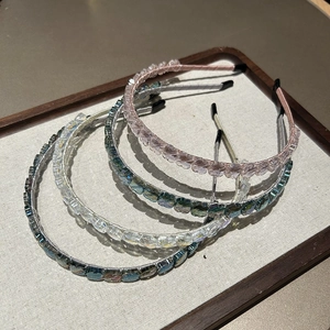 Détail de quatre serre-têtes faits main avec fleurs en cristal en plusieurs couleurs