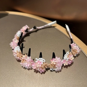 Detail of pink and white beaded flower headband with black non-slip hair comb structure