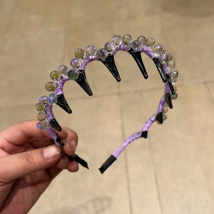 Detail eines lila Seidenstirnbands mit zweireihigen Kristallperlen und Innenzähnen