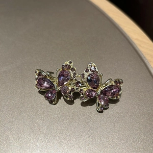 Eleganter goldener Doppel-Schmetterling-Haarclip mit funkelnden lila Kristallen