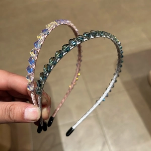Détail de serre-têtes perlés avec fleurs en cristal et embouts protecteurs aux bouts