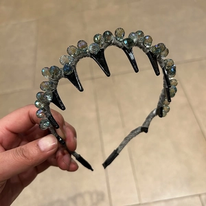 Detailansicht von blaugrauen Kristallperlen und glänzenden schwarzen Spikes auf einem Haarreif