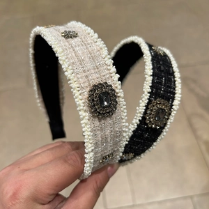 Detailed view of tweed headbands in black and cream with pearls and crystal accents