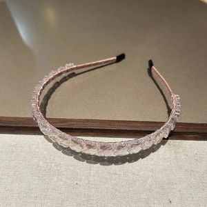 Détail des perles de cristal rose sur un serre-tête fin avec embouts protecteurs