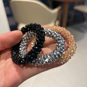 Macro shot of sparkling crystal pearl hair ties in black, silver, and champagne gold colors