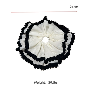 Détail d'un chouchou géant noir et blanc de 24 cm montrant les dimensions réelles