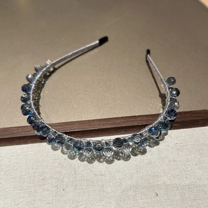 Détail d'un serre-tête en cristal de luxe avec perles bleues tissées main sur monture