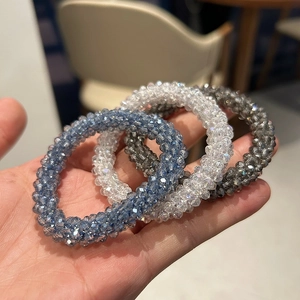 Close-up of a three-piece set of faceted crystal bead elastic hair ties in grey and blue