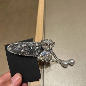 Vue détaillée d'une barrette à nœud strass avec perles en forme de goutte et cristaux