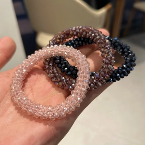 Detailed view of handmade crystal beaded hair ties in pink, purple and navy blue
