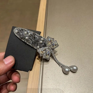 Détail d'une pince à cheveux papillon avec cristaux, perles et longues franges