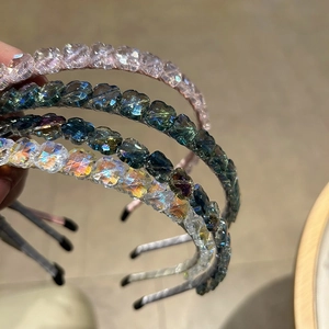 Gros plan de quatre serre-têtes en cristal fleur à quatre feuilles en rose, bleu et violet
