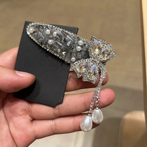 Détail de la pince à cheveux papillon ornée de cristaux et de glands en perles