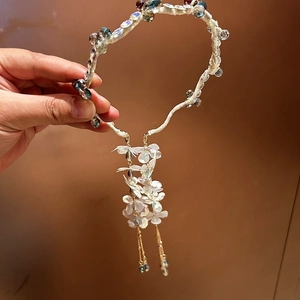 Detail of crystal floral headband featuring delicate tassels and iridescent bead accents