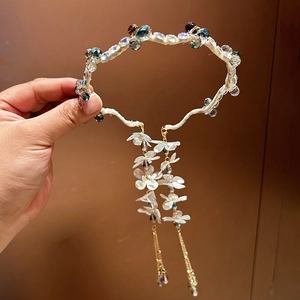 Detail of handcrafted beaded floral headband with long iridescent tassels and gold chains