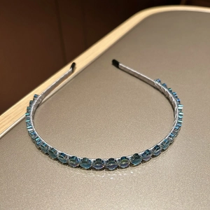 Détail du serre-tête en cristal bleu clair avec facettes irisées et gaine en tissu