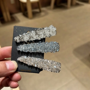 Close-up of sparkling rhinestone hair clips in silver, blue and champagne tones