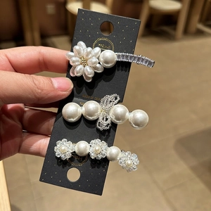 Detaillierte Ansicht des dreiteiligen Perlen-Haarspangen-Sets mit Blumen- und Schleifendesign