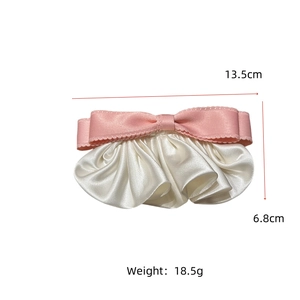 Vue détaillée du nœud en satin rose montrant les dimensions de 13,5 cm de large et 6,8 cm