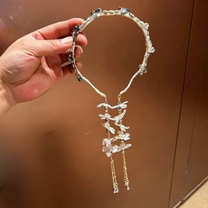 Detail of crystal flower headband featuring dark beads and delicate gold fringe tassels