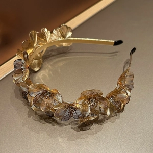 Detailed view of golden metal flower headband featuring brushed petals and shiny rhinestones