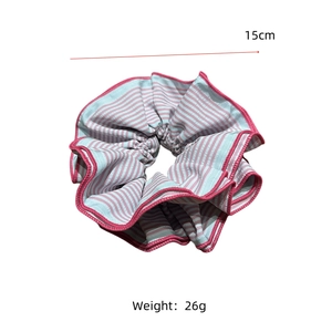 Détail d'un chouchou rayé en tissu avec bordures roses, diamètre 15cm et poids de 26g