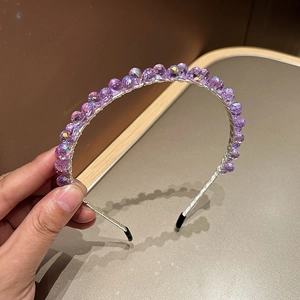 Detailed view of hand-woven purple crystal beads on a slim silver metal luxury headband