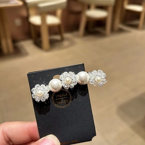 Eleganter Haarclip im koreanischen Stil mit Kristallblumen und Perlen auf schwarzer Karte