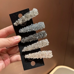 Close-up of five-piece set of sparkling rhinestone hair clips on a black card display