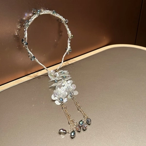Detail of floral headband featuring crystal fringe tassels and iridescent blue beads