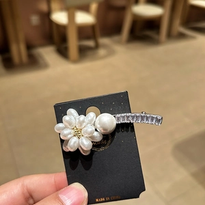 Nahaufnahme der Perlenblumen-Haarklammer mit Kristallen auf einer Displaykarte für Haare