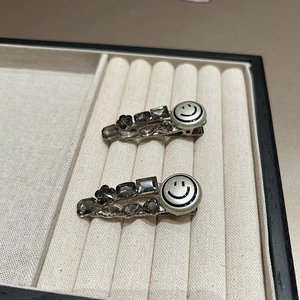Close-up of sparkling rhinestone hair clips with smoky crystals and a silver smiley face