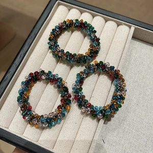 Three premium crystal beaded elastic hair ties with colorful multifaceted beads on a tray