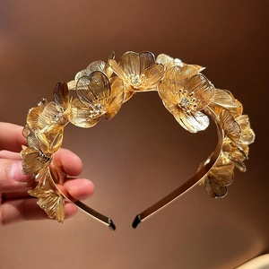 Detail of golden ginkgo leaf headband featuring intricate rhinestone floral pattern