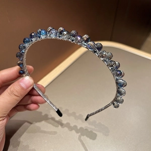 Détail de perles en cristal bleu montées à la main sur un serre-tête fin argenté