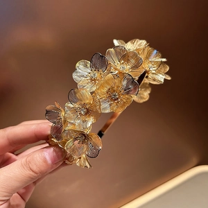 Detail of woven gold flower headband with sparkling rhinestones and leaf motifs