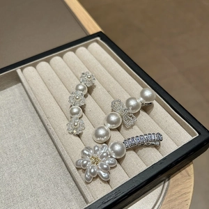 Detail von dreiteiligem Perlen-Haarklammer-Set mit Schleife und Blumen-Design im Tablett