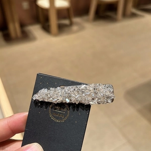 Close-up of a handmade rectangle rhinestone hair clip with shimmering crystals