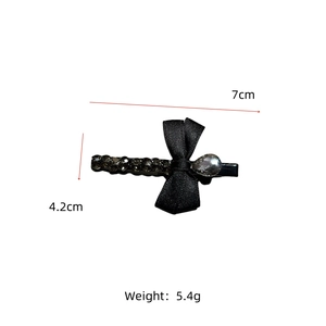 Détail de la barrette nœud en velours noir avec strass gris et dimensions de 7cm par 4,2cm